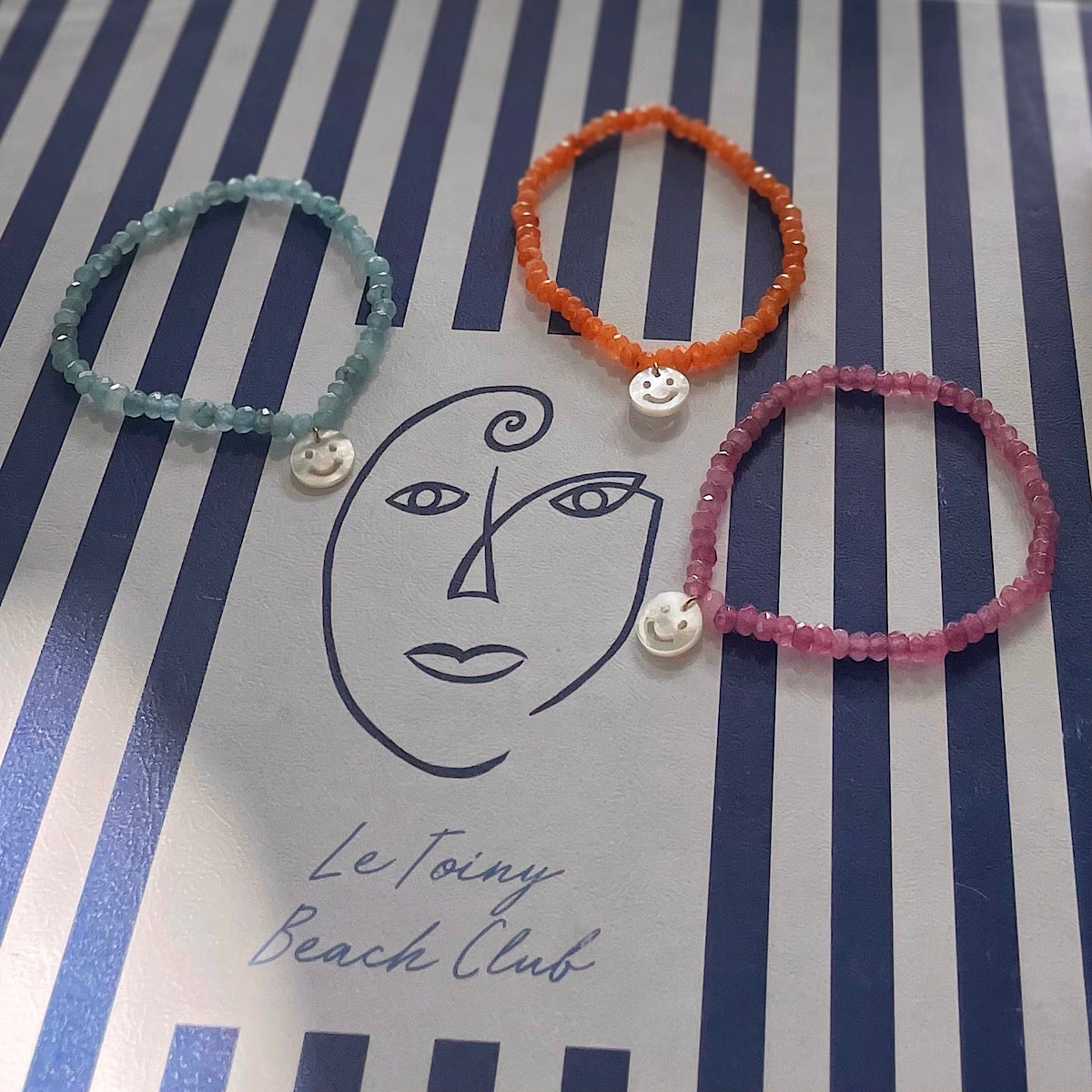 gemstone bracelets in orange, turquoise and purple with shimmering smiley pearl charm