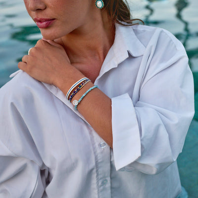 woman wearing blue and white summer pearl and gemstone bracelets