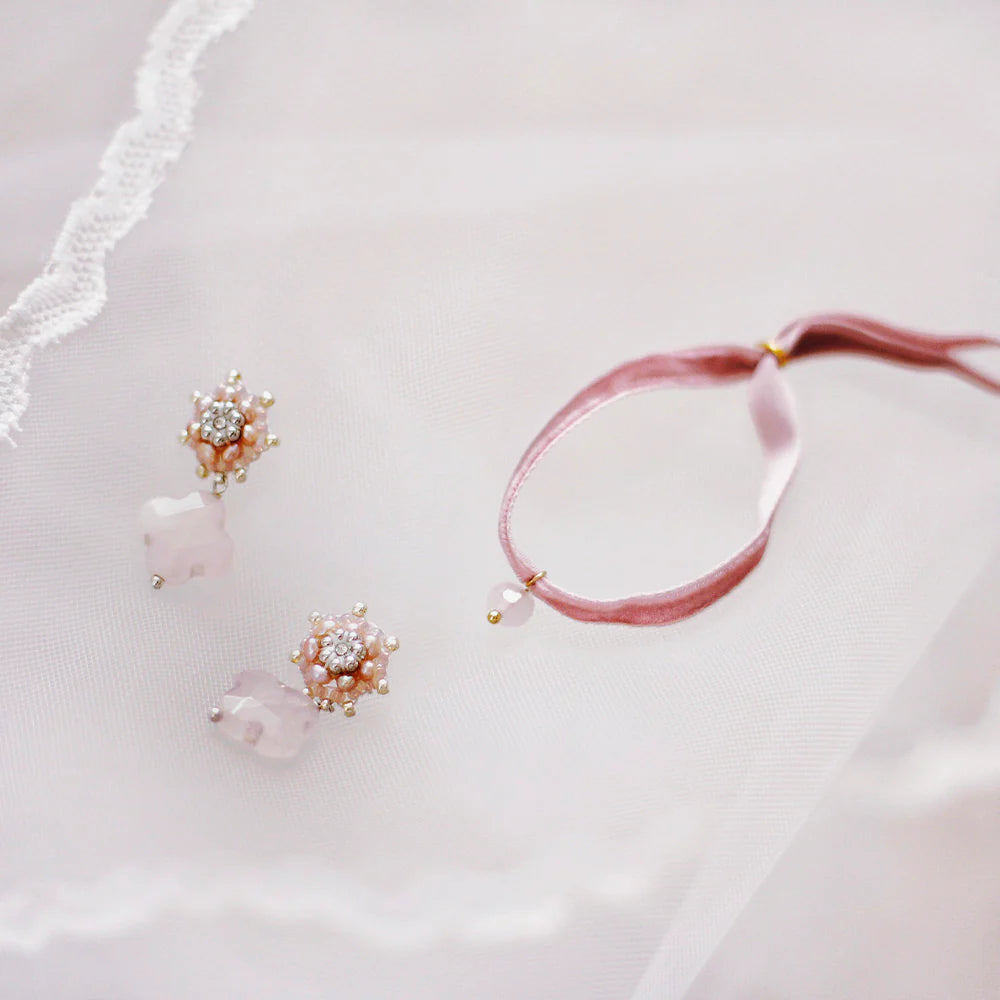 A pair pink earrings with clover-shaped drops made of rose quartz and pink pearls with a matching velvet bracelet.