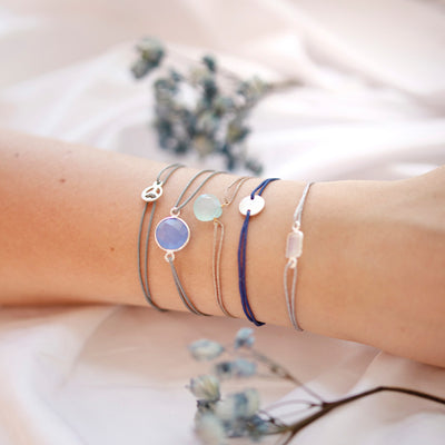 grey nylon thread bracelet with small silver peace pendant