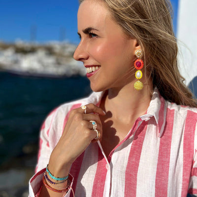 Designerin Mascha Lina Borodin trägt Stretchring aus kleinen weißen Süßwasserperlen und einer 18 Karat vergoldeten Perle kombiniert mit Kiwi Streifen-Kleid in Mykonos.