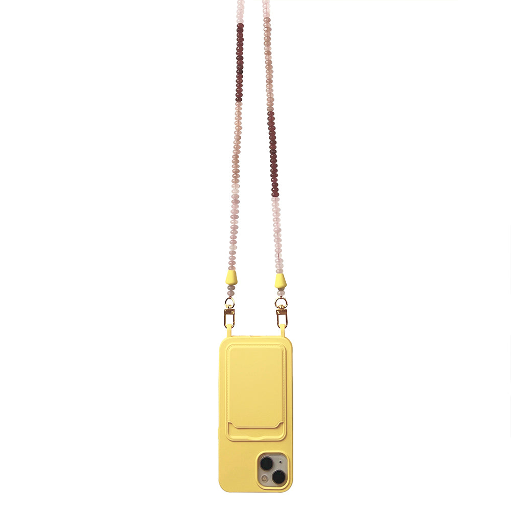 A trendy beach accessory: gold, brown, and nude gemstone necklace phone chain matched with a sunny yellow phone case.
