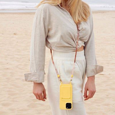 Wear a Baywatch inspired outfit to your beach day with a summer yellow phone case and matching nude, brown, and gold phone chain necklace.