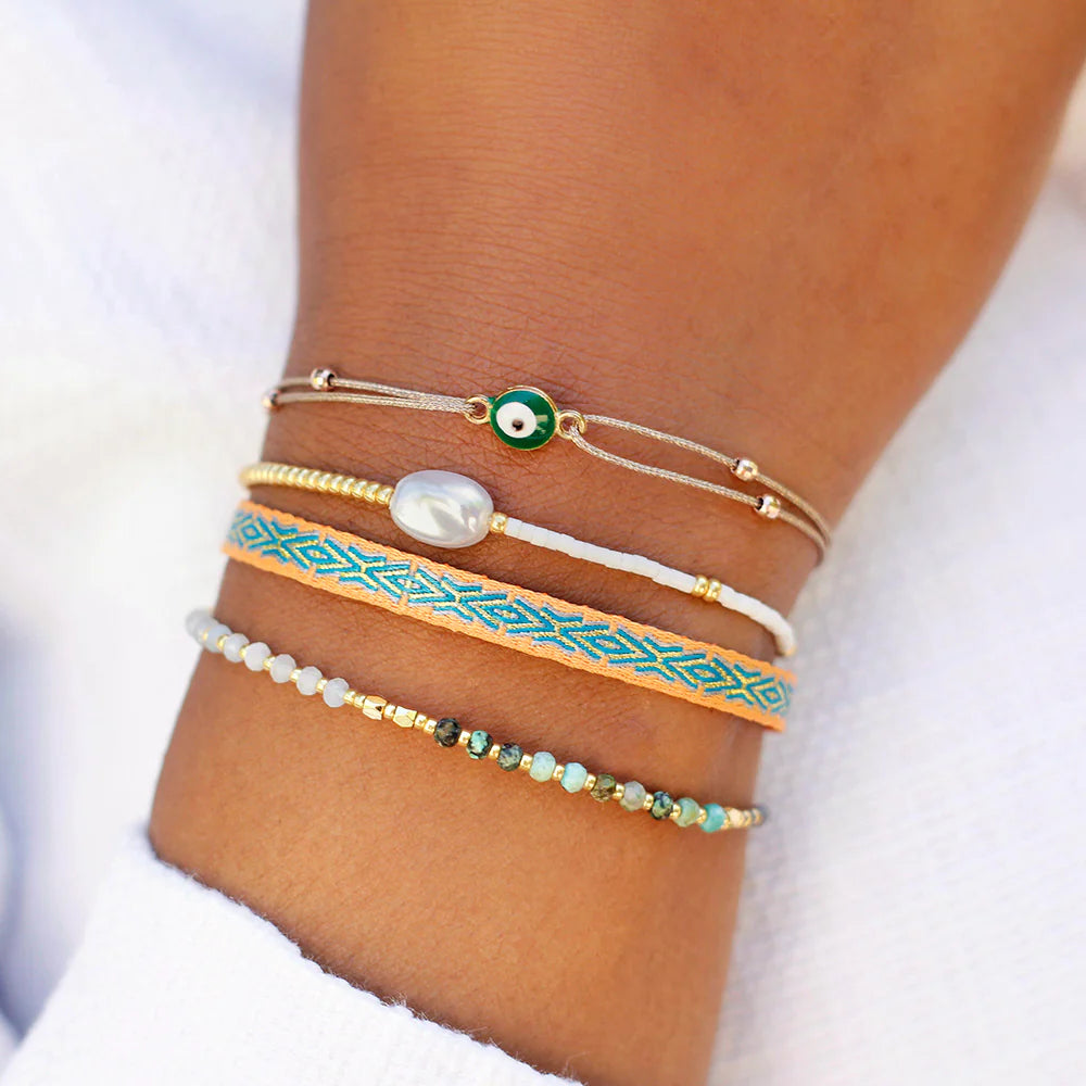 An arm displaying a colourful bracelet set.