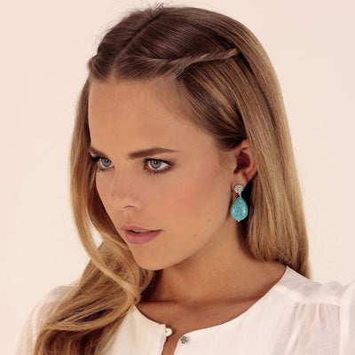 woman wearing small silver earrings with turquoise howlite stone