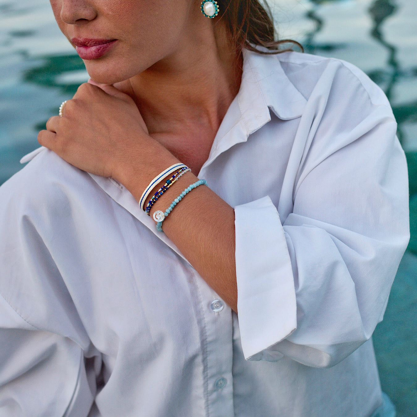 woman wearing blue and white summer pearl and gemstone bracelets