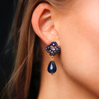 A woman wearing elegant ball season blue earrings.