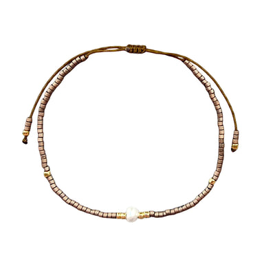One pearl strand of a three strand black-and-white beige bracelet set.