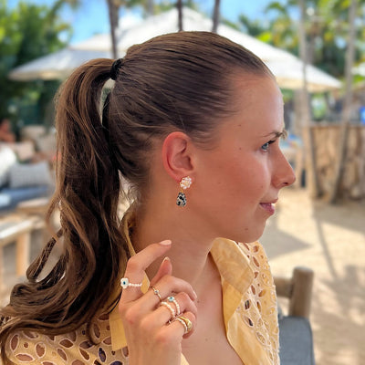 woman wearing small drop earrings with dalmatis jasper charm