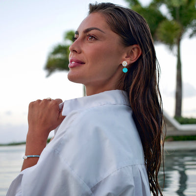 woman wearing turquoise shell earrings from freshwater pearls and mother of pearl charm 