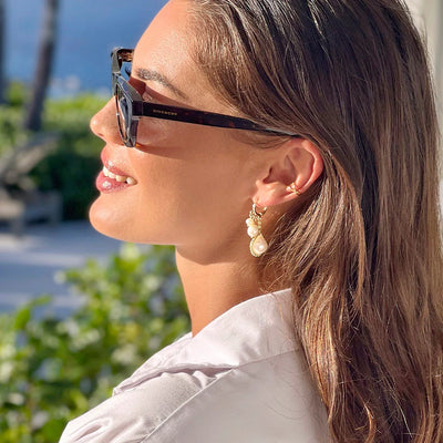 A woman wearing elegant real pearl earrings at Venice beach.