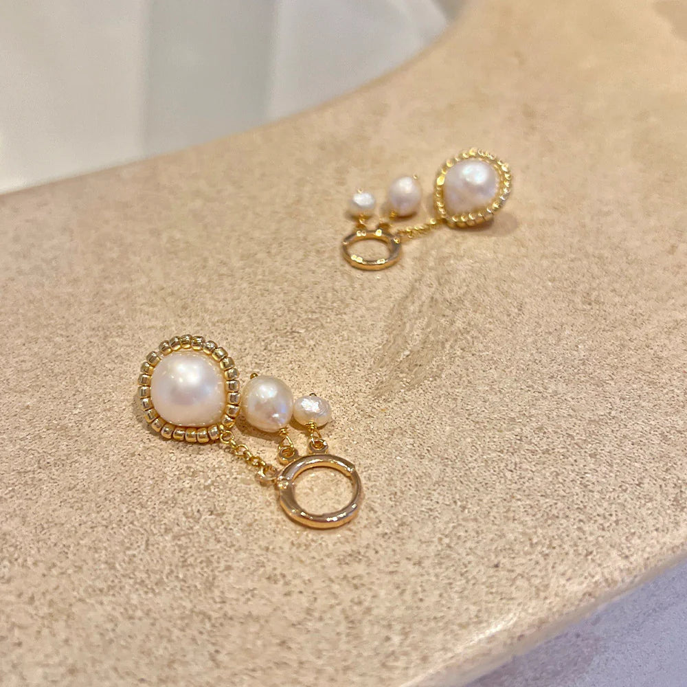 Gold hoop earrings with real freshwater pearl earrings displayed in a spa setting.