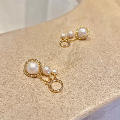 Gold hoop earrings with real freshwater pearl earrings displayed in a spa setting.