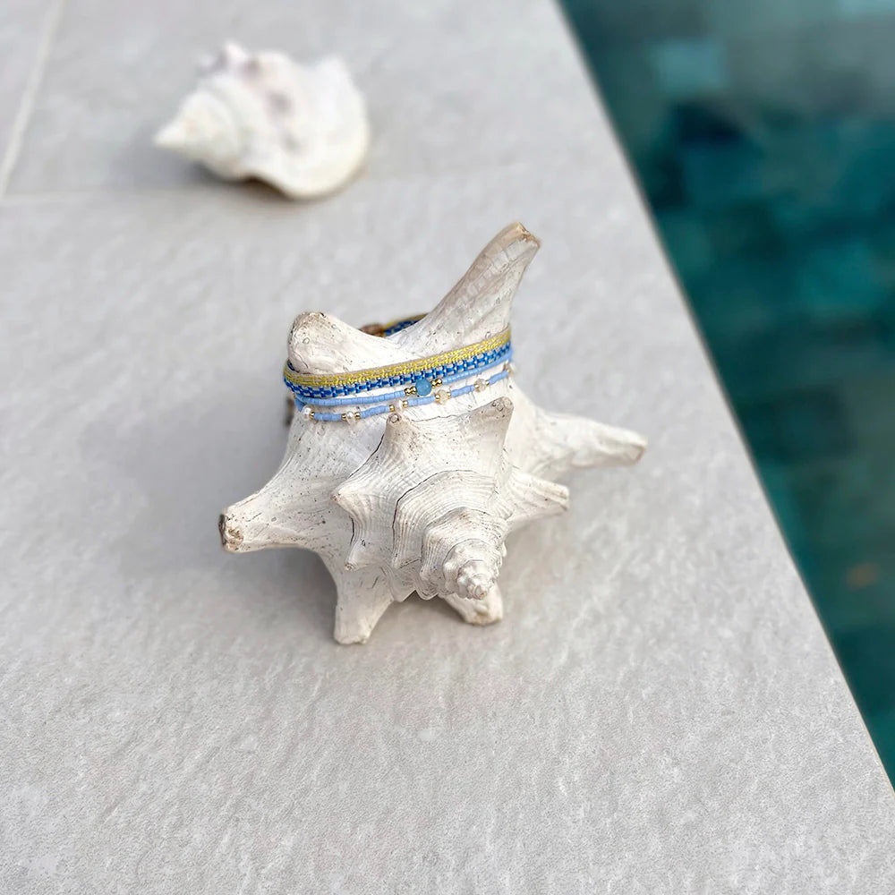 An ocean blue bracelet displayed in a conch shell near Miami beach.