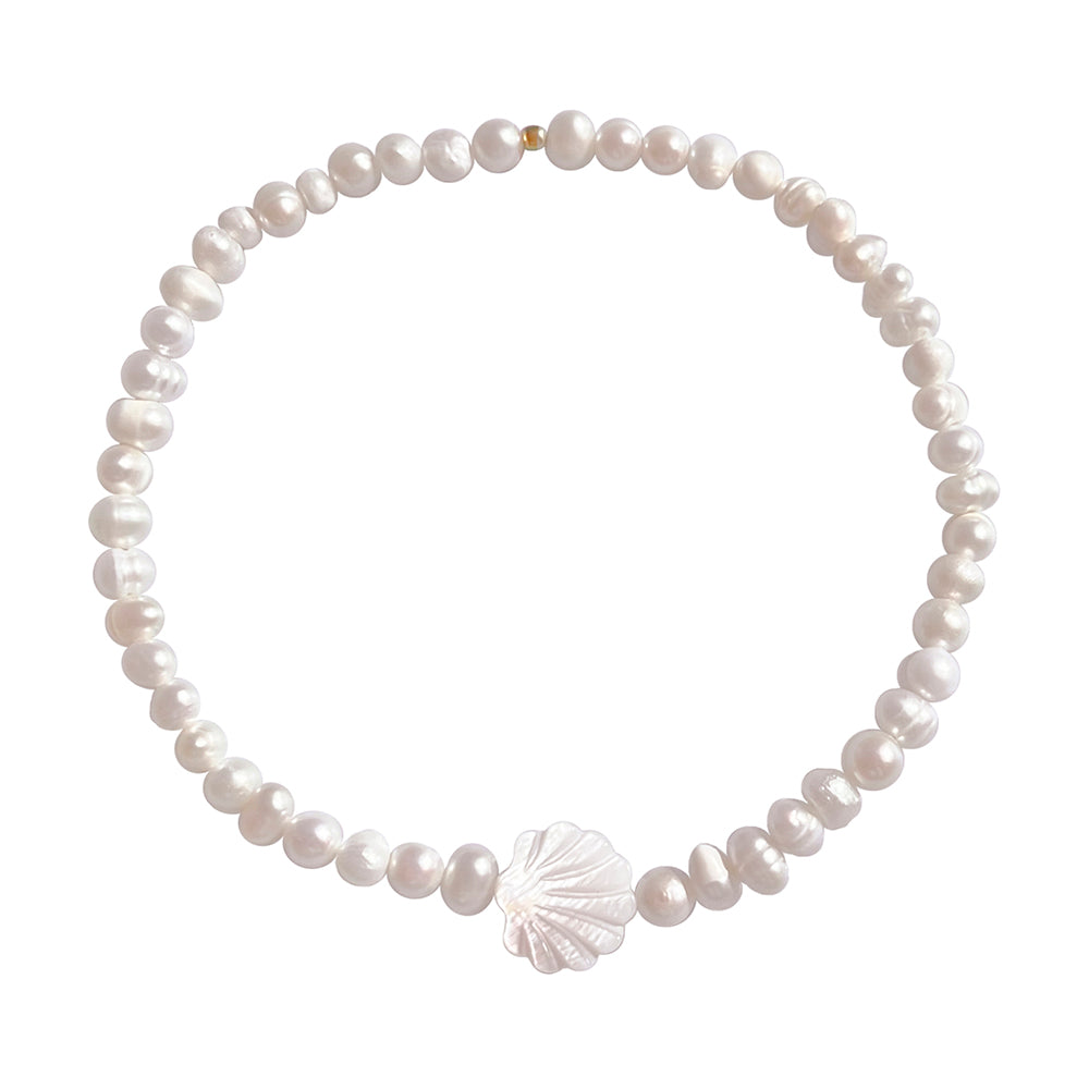Schimmernde weiße Schmuckstücke, aus zeitlosen Perlen formen moderne Schmuckstücke, die auf einem coolen Teller im Seeigel Look präsentiert sind.