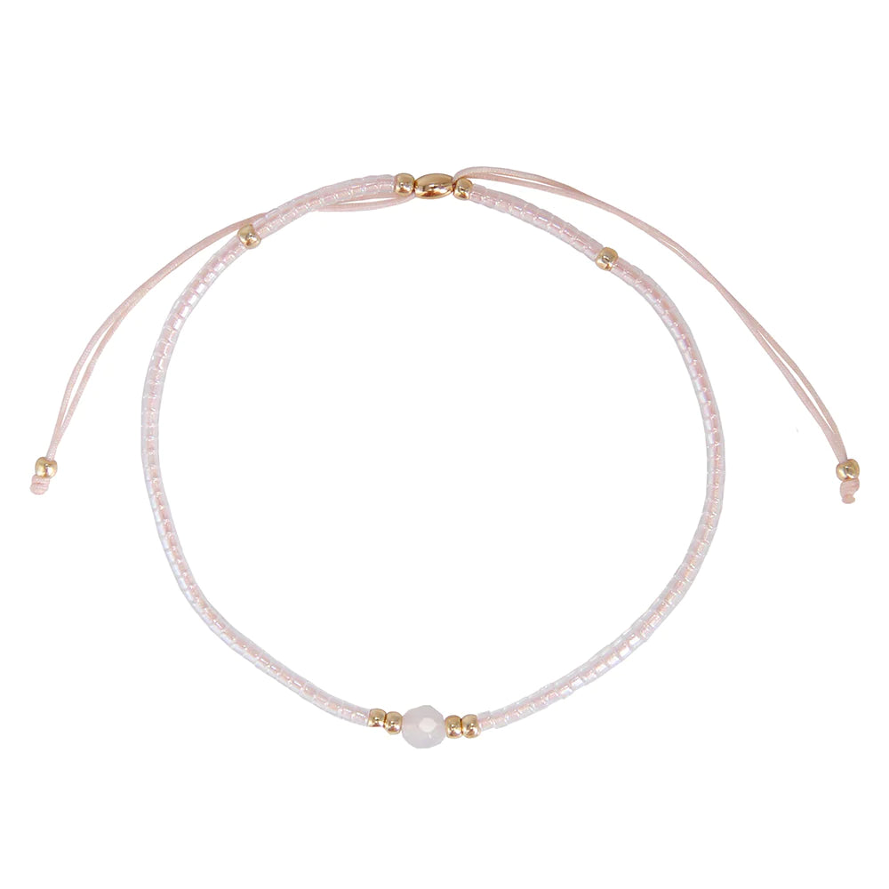 One pearl strand of a pink three strand bracelet set.