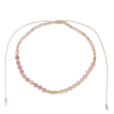 One bead strand of a pink three strand bracelet set.