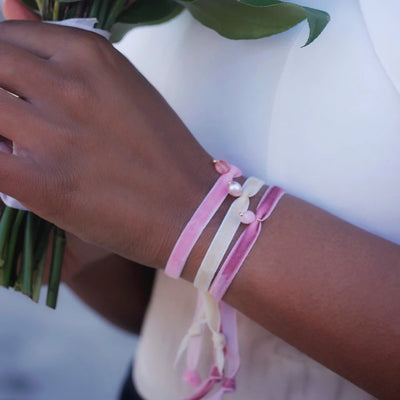 Dream wedding day: a bride wearing pink and white velvet bracelets with natural stone charms.