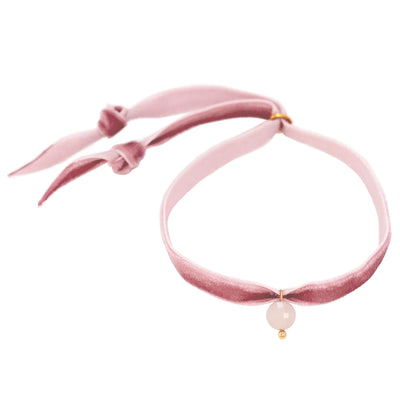 A pink velvet bracelet with a rose quartz charm.