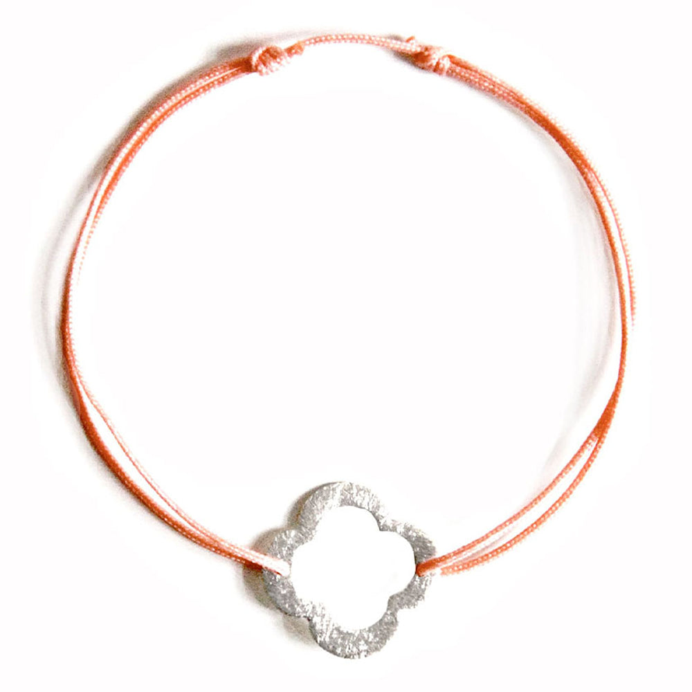 coral coloured nylon thread bracelet with silver flower shaped pendant