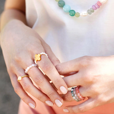 stretch ring out of small white freshwater pearls and a gold flower shaped nacre