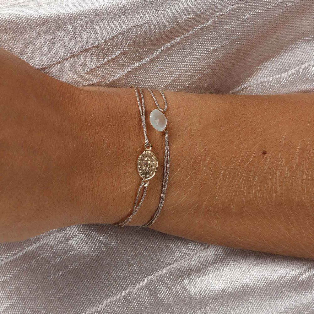 glittery beige nylon thread bracelet with gold plated talisman