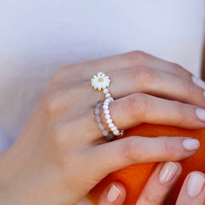 stretch ring with small white freshwater pearls and sunflower shaped nacre 