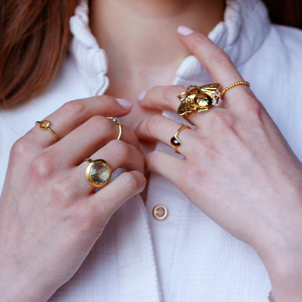 gold plated ring with purple teardrop shaped garnet gemstone 