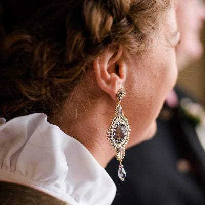Bellas-Gründerin Jeannette Conrad trägt ein Susanne Spatt Dirndl mit große Statement Ohrringe mit rundem taupefarbenem Achatstein und silbernen und goldenen Perlen zu Ihrer Mirabell Hochzeit in Salzburg.
