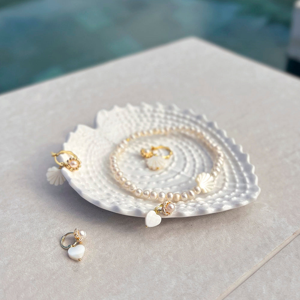 Die kleinen Perlenhoops bestehen aus einem Perlmutt Herz, einer Süßwasserperle und einer Echt Silber vergoldeten Kreole an der der Herzanhänger schimmert.