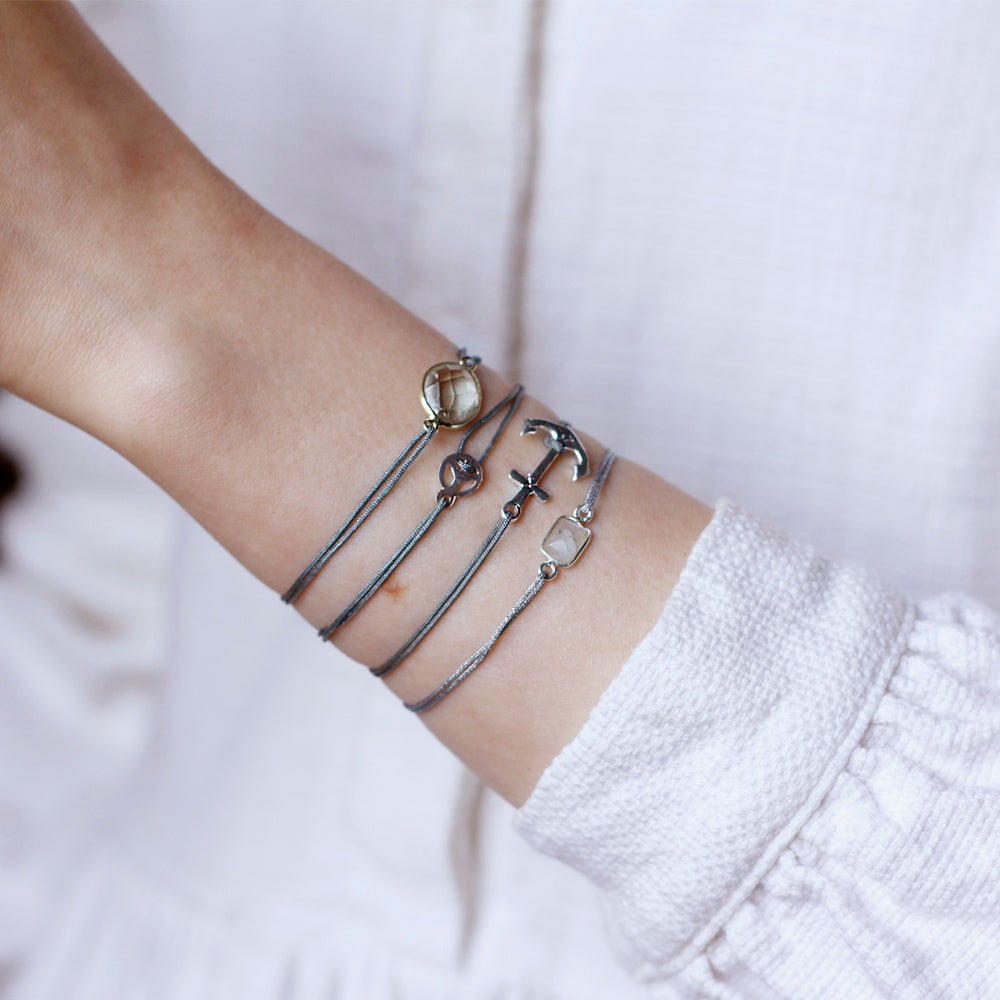 grey nylon thread bracelet with small silver peace pendant