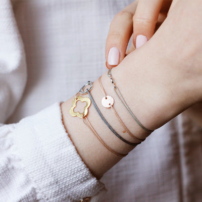 beige nylon thread bracelet with golden flower shaped pendant