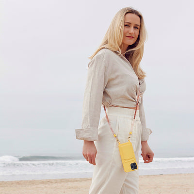 Bondi beach outfit with summer yellow sun phone case and trendy nude phone necklace chain.