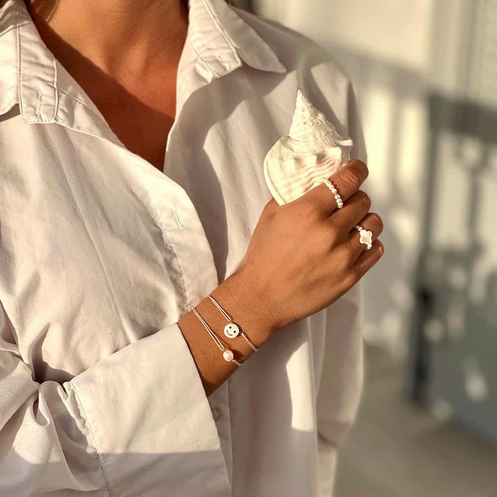 Good morning vibes from St. Barths with a white shirt, beach shell and beautiful white symbol and pearl jewlery.