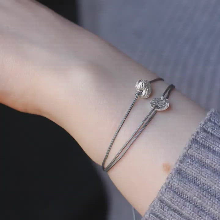 grey nylon thread bracelet with heart-shaped silver pendant